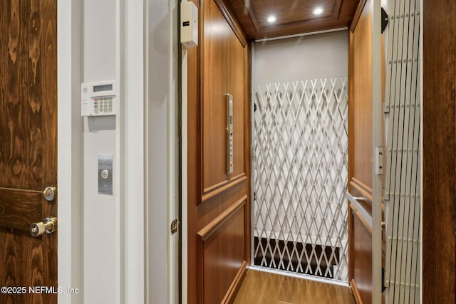 interior details with recessed lighting, elevator, and wood finished floors