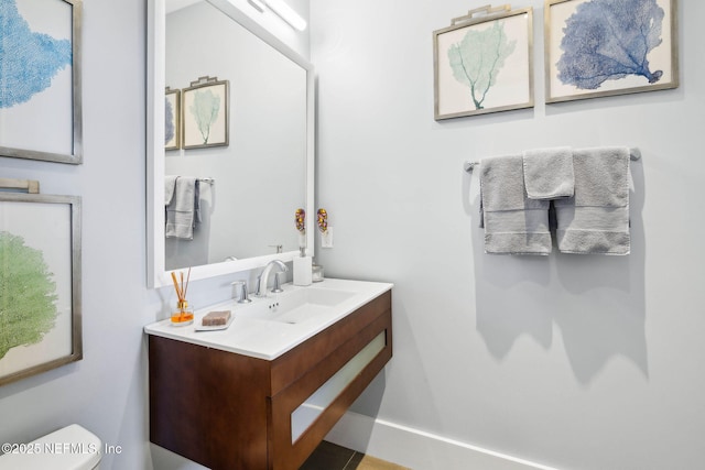 half bathroom with vanity and toilet