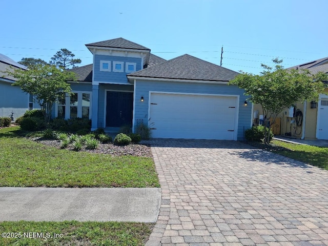 view of front of property featuring decorative driveway, an attached garage, and a front lawn