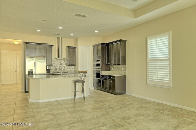 2924 Sea Grape Dr S, Fernandina Beach, FL 32034 - kitchen featuring decorative backsplash, wall chimney range hood, recessed lighting, appliances with stainless steel finishes, and an island with sink