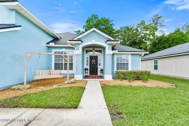 45103 Amhurst Oaks Dr, Callahan, FL 32011 - view of front of property featuring a front lawn, stucco siding, and roof with shingles