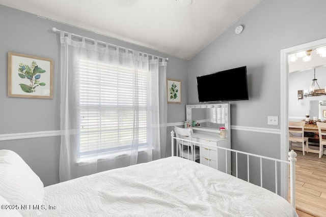 45103 Amhurst Oaks Dr, Callahan, FL 32011 - bedroom with lofted ceiling, wood finished floors, and a chandelier