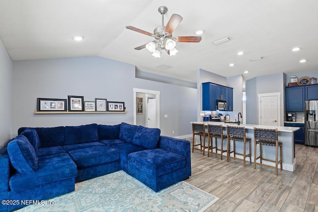 45103 Amhurst Oaks Dr, Callahan, FL 32011 - living room featuring vaulted ceiling, ceiling fan, recessed lighting, light wood-type flooring, and baseboards