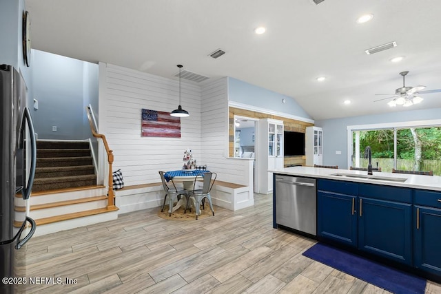 45103 Amhurst Oaks Dr, Callahan, FL 32011 - kitchen featuring appliances with stainless steel finishes, a sink, blue cabinetry, vaulted ceiling, and light wood-style floors