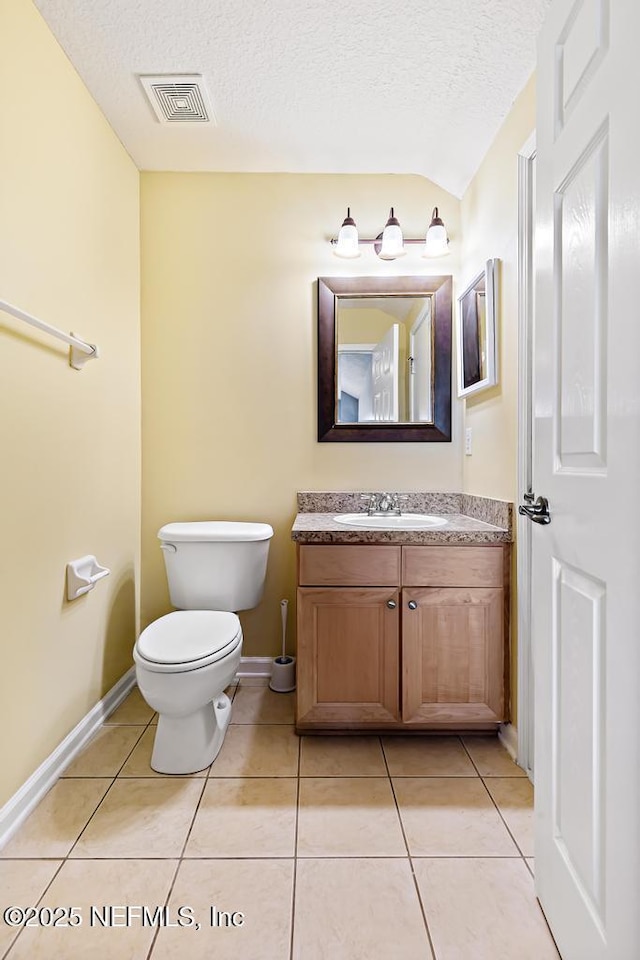45103 Amhurst Oaks Dr, Callahan, FL 32011 - bathroom with a textured ceiling, toilet, tile patterned floors, vanity, and baseboards