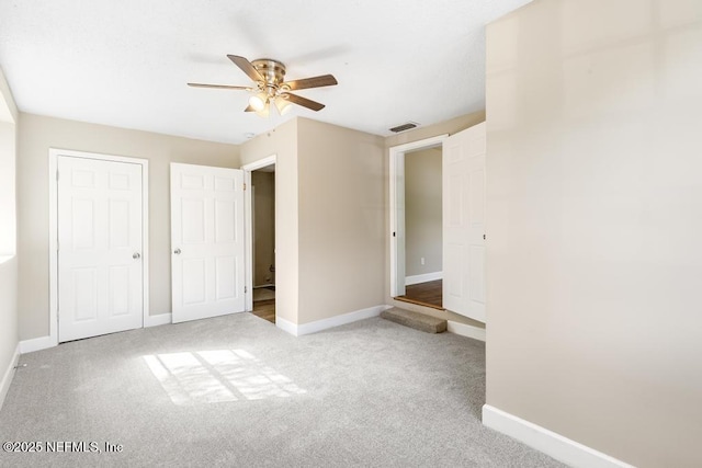 unfurnished bedroom featuring visible vents, carpet, and baseboards