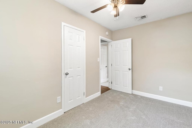 unfurnished bedroom featuring visible vents, carpet flooring, baseboards, and a ceiling fan