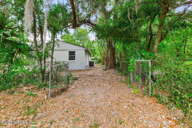 view of yard featuring fence and central AC unit