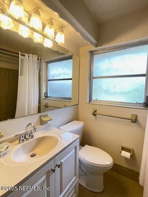 bathroom featuring toilet, vanity, and a shower with shower curtain