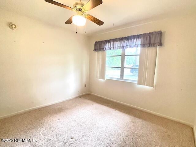 unfurnished room with carpet flooring, baseboards, and a ceiling fan