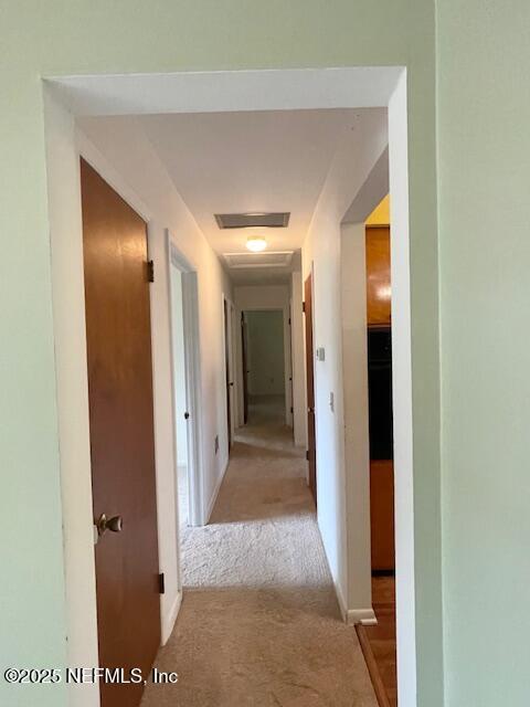hall with light carpet and baseboards