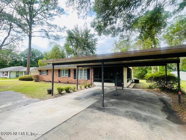 view of parking featuring driveway and a carport