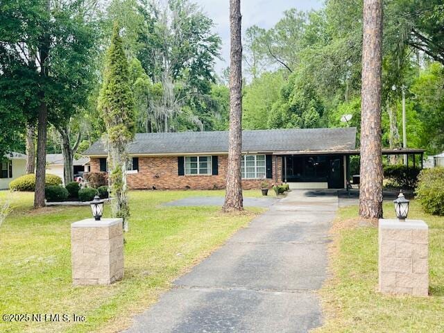 ranch-style house with asphalt driveway, a front yard, and brick siding