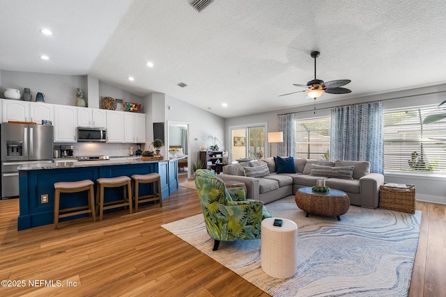 1421 Kipling Ln, Ponte Vedra, FL 32081 - living area featuring light wood-style floors, vaulted ceiling, a ceiling fan, a textured ceiling, and recessed lighting