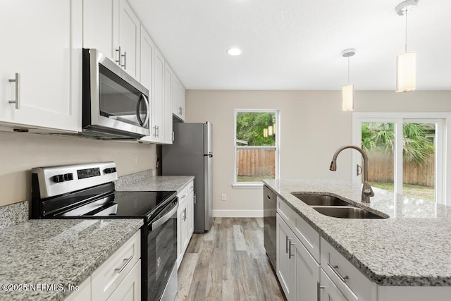 2911 Wilcox St, Jacksonville, FL 32209 - kitchen featuring a sink, baseboards, white cabinets, stainless steel appliances, and light wood-style flooring