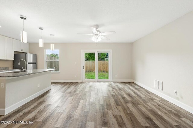 2911 Wilcox St, Jacksonville, FL 32209 - unfurnished living room featuring baseboards, ceiling fan, wood finished floors, and visible vents