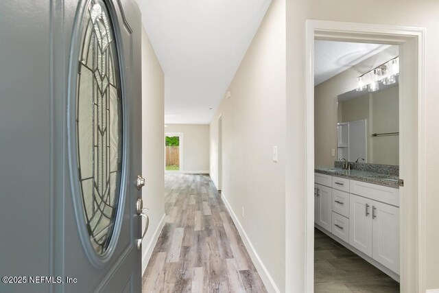 2911 Wilcox St, Jacksonville, FL 32209 - hallway featuring baseboards, a sink, and light wood finished floors
