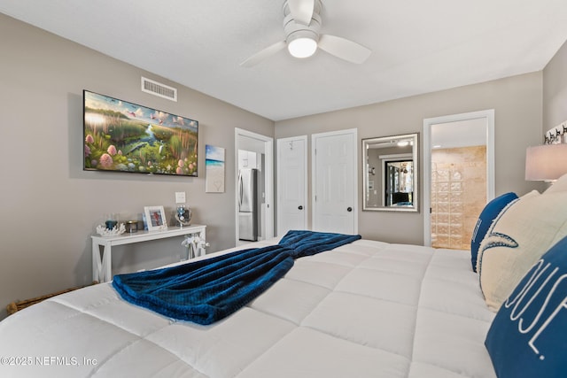 bedroom with freestanding refrigerator, a ceiling fan, ensuite bath, and visible vents