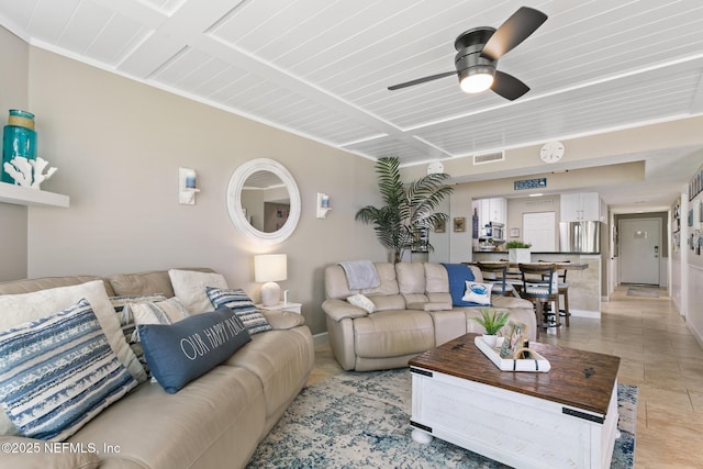 living area with a ceiling fan, baseboards, and visible vents
