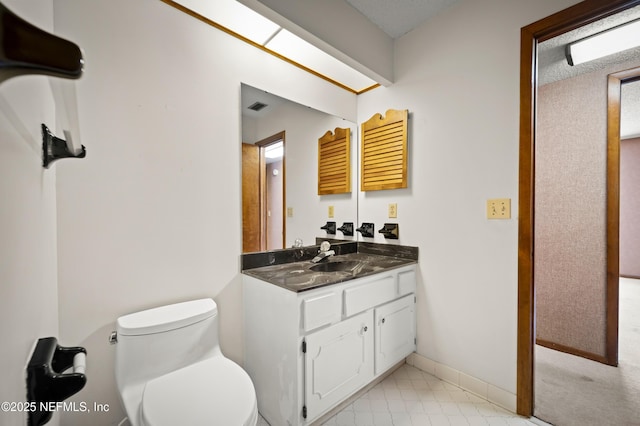 bathroom featuring vanity, baseboards, toilet, and visible vents