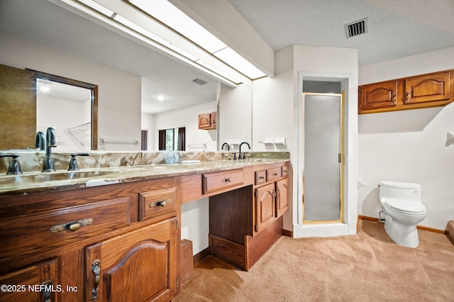full bath with double vanity, visible vents, a shower stall, a sink, and toilet