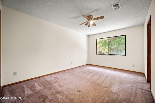 carpeted empty room featuring a ceiling fan, a textured ceiling, visible vents, and baseboards