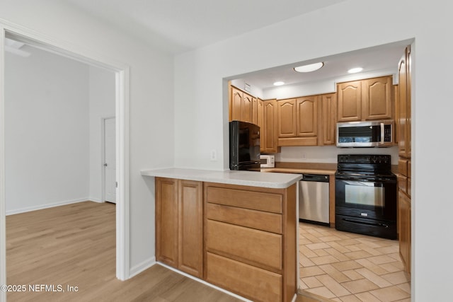 4746 Gulfstream Ct, Fernandina Beach, FL 32034 - kitchen with a peninsula, baseboards, black appliances, light countertops, and recessed lighting