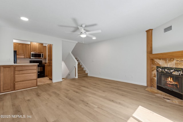4746 Gulfstream Ct, Fernandina Beach, FL 32034 - unfurnished living room featuring light wood-type flooring, visible vents, a ceiling fan, and stairway