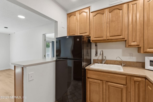 4746 Gulfstream Ct, Fernandina Beach, FL 32034 - kitchen featuring a sink, white microwave, freestanding refrigerator, recessed lighting, and light countertops