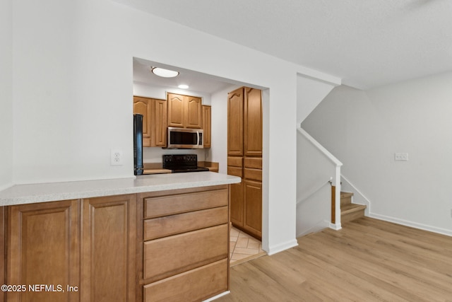 4746 Gulfstream Ct, Fernandina Beach, FL 32034 - kitchen featuring recessed lighting, light wood finished floors, black / electric stove, stainless steel microwave, and light countertops
