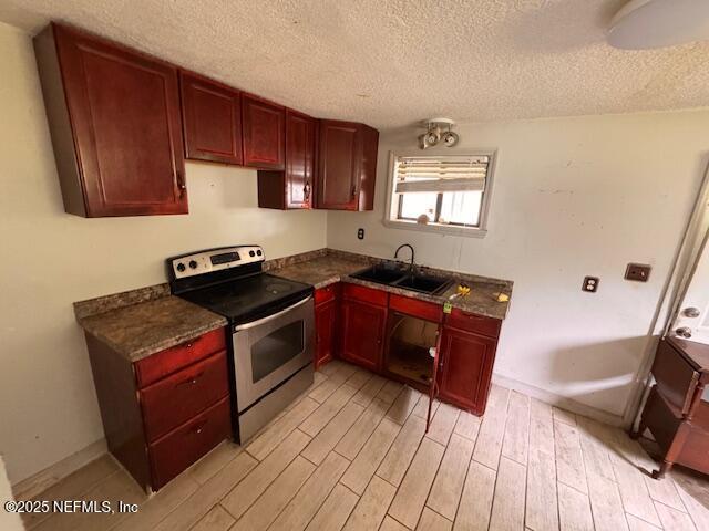 kitchen featuring stainless steel electric range oven, dark brown cabinets, a textured ceiling, and a sink