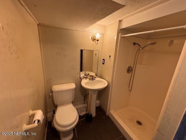 full bath featuring a stall shower and toilet
