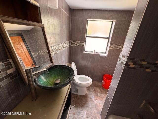 bathroom with vanity, toilet, and stone tile flooring