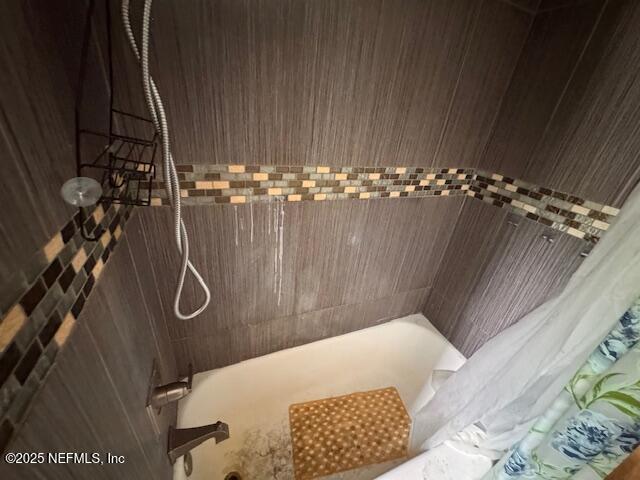 bathroom with shower / bath combo with shower curtain