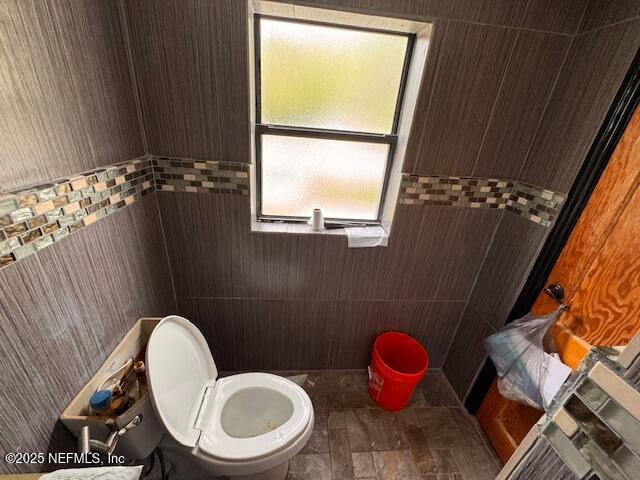 bathroom with stone finish flooring and toilet