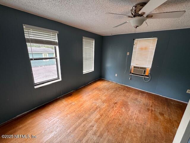 unfurnished room featuring a ceiling fan, hardwood / wood-style flooring, and a textured ceiling