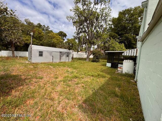 view of yard featuring fence and an outdoor structure
