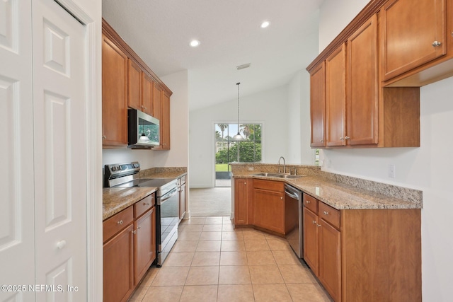 1201 Coghill Cir, Saint Augustine, FL 32092 - kitchen featuring appliances with stainless steel finishes, brown cabinets, a sink, lofted ceiling, and recessed lighting