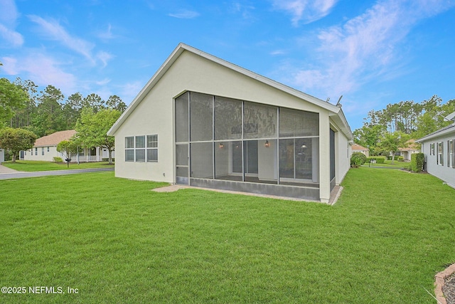 1201 Coghill Cir, Saint Augustine, FL 32092 - back of house featuring a yard, a sunroom, and stucco siding