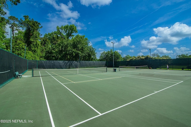 view of tennis court featuring fence and community basketball court