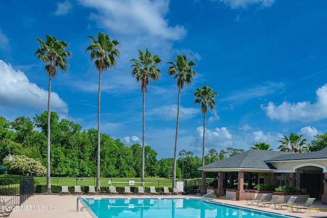 pool with a patio and fence