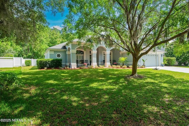 view of front of house featuring fence, stucco siding, driveway, and a front yard