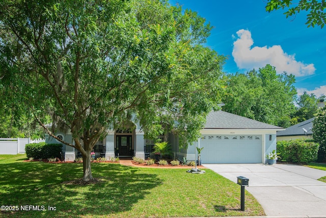 view of property hidden behind natural elements with a garage, fence, a front lawn, concrete driveway, and stucco siding