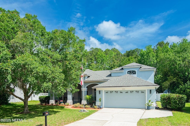 view of front of house featuring a shingled roof, a garage, stucco siding, a front yard, and concrete driveway