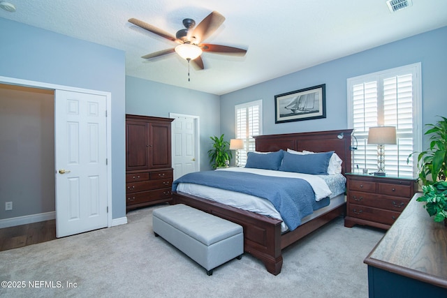 bedroom featuring a ceiling fan, baseboards, light colored carpet, and visible vents