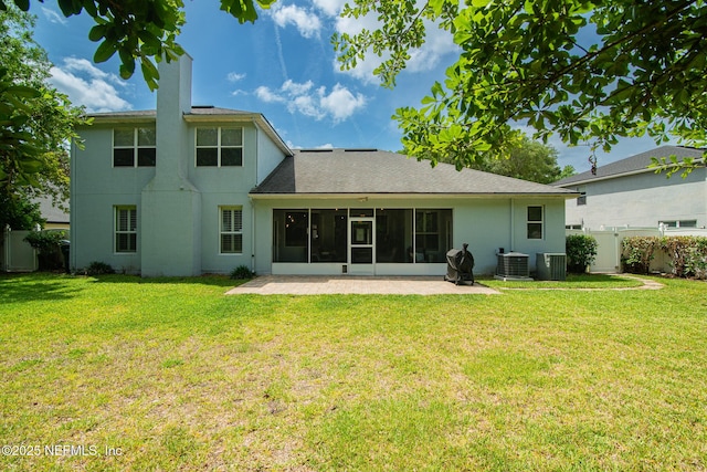 rear view of house featuring a sunroom, a lawn, fence, and central AC