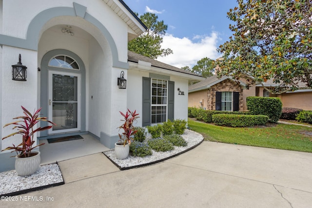 doorway to property featuring stucco siding