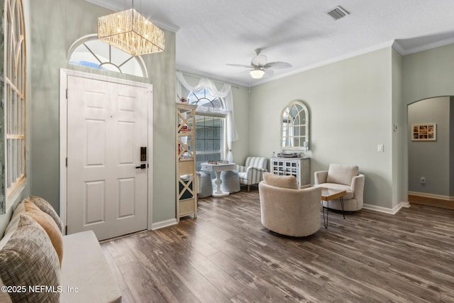 entryway featuring crown molding, wood finished floors, and visible vents