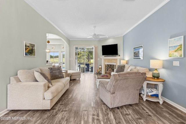 living area featuring crown molding, baseboards, and wood finished floors