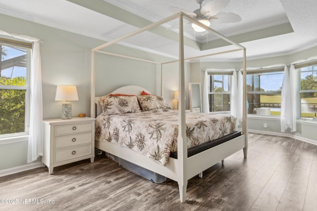 bedroom featuring ornamental molding, a ceiling fan, and wood finished floors